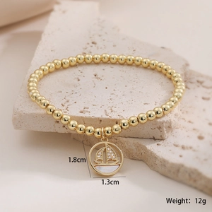 Détail du pendentif voilier plaqué or 18 carats avec zircons et nacre sur le bracelet