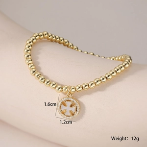 Détail du bracelet à perles plaqué or 18 carats avec pendentif croix et zircons