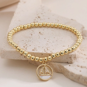Bracelet à perles plaqué or 18K avec pendentif voilier et nacre blanche au style épuré