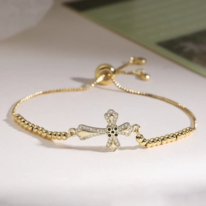 Détail du bracelet croix plaqué or 18K avec zircons blancs et pierres noires