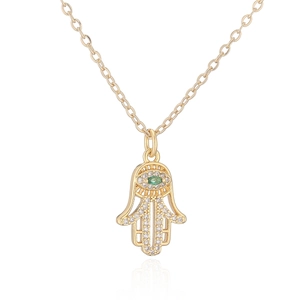 Vue détaillée du collier main de Hamsa dorée avec zircons et œil porte-bonheur vert
