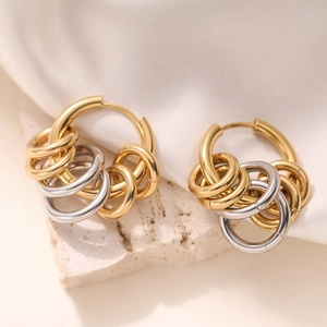 Polished 18K gold and silver stainless steel layered hoop earrings on stone background