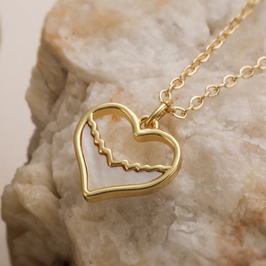 Collier cœur plaqué or 18 carats avec nacre blanche sur fond de pierre naturelle sobre