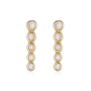 Detailed view of long vertical 18K gold plated earrings with five sparkling cubic zirconia stones