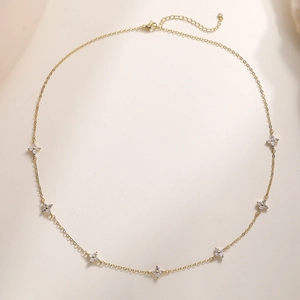 18K gold plated necklace with seven zircon flower pendants on a warm beige background