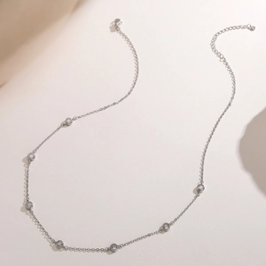 Detail view of silver finish station necklace with seven bezel-set cubic zirconia stones