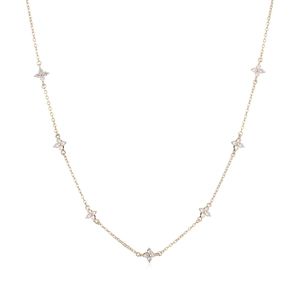 Close-up of gold flower necklace with clear zircon stones on a clean white background