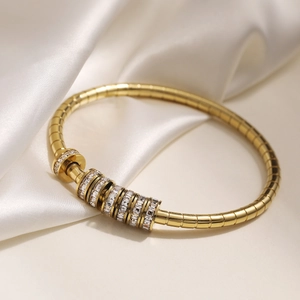 Luxury 18K gold plated stainless steel bracelet with zircon transfer beads on silk background