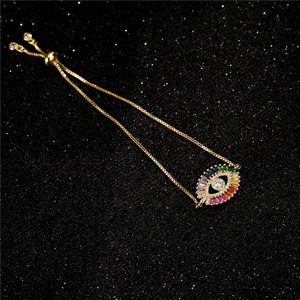 Bracelet ajustable œil porte-bonheur doré avec zircons multicolores sur fond noir