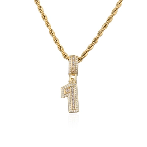 Vue macro détaillée du pendentif chiffre 1 doré avec pierres de zircon sur une chaîne corde