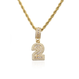 Gros plan du pendentif chiffre 2 plaqué or avec zircons micro-pavés et chaîne de corde