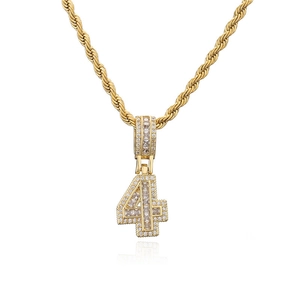 Détail macro du pendentif hip-hop chiffre 4 doré serti de zircons brillants