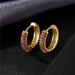 Macro de boucles d'oreilles créoles dorées avec pavage de zircons roses sur plusieurs rangs