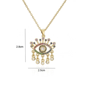 Vue macro du pendentif Mauvais Œil plaqué or 18 carats avec zircons colorés et charms