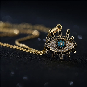Collier avec pendentif Mauvais Œil plaqué or 18 carats et oxydes de zirconium sur fond noir