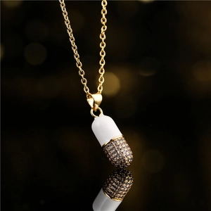 Collar con colgante de cápsula en esmalte blanco y cristales oscuros en cadena oro