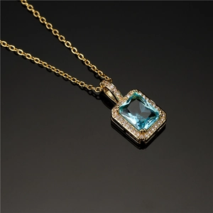 Elegante goldene Halskette mit rechteckigem blauem Zirkon-Anhänger auf schwarzem Grund