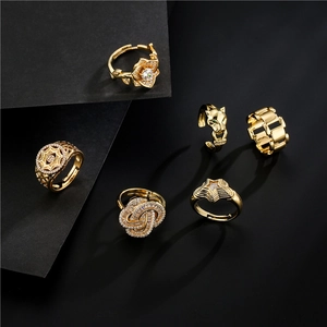 Golden rings set with green-eyed leopard, rose and star patterns on black background