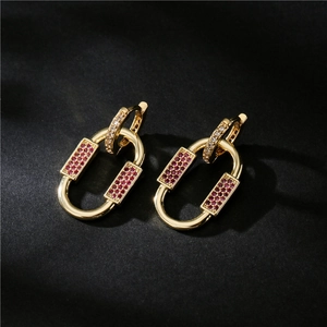 Macro detail of 18K gold chain link earrings with red and white pave-set zircons