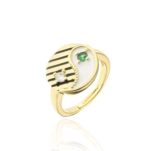Detail of yin-yang ring featuring white enamel, green gem, and gold-plated cubic zirconia