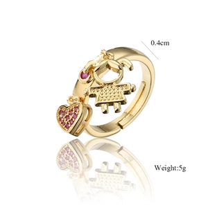 Detail of 18K gold ring with girl charm and heart pendant set with purple zircons