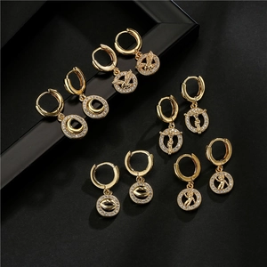 Detalle de pendientes de aro bañados en oro de 18K con colgantes de circonitas variadas