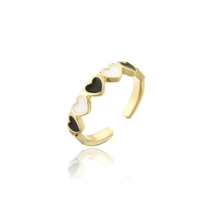 Détail d'une bague dorée ajustable avec des cœurs en émail noirs et blancs alternés