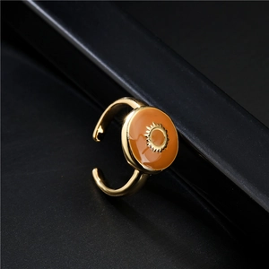 18K gold plated adjustable ring with orange enamel sunburst design on dark background