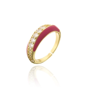 Détail macro d'une bague dorée ouverte avec émail rose vif et incrustation de zircon