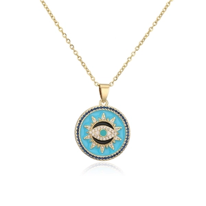 Detailed close-up of golden evil eye pendant with blue enamel and sparkling zircon accents