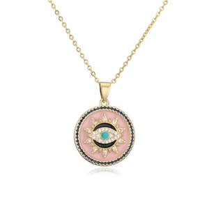 Detail of gold sunburst Evil Eye pendant with pink enamel and blue crystals