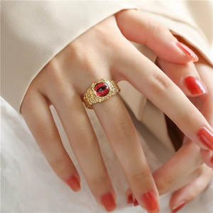 Detailed close-up of bohemian 18K gold plated ring with hammered texture and red eye element