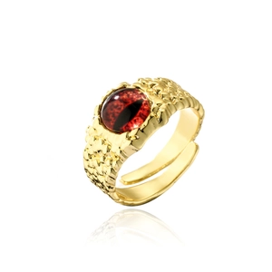 Macro detail of vintage 18K gold plated eye ring with red stone and dragon scale texture