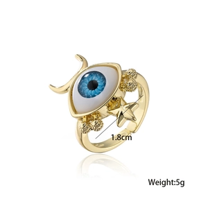 Macro detail of gold plated evil eye ring with blue iris and celestial star accents