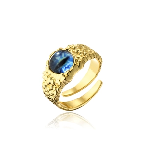 Detailed macro view of gold-plated evil eye ring with blue pupil and scale texture