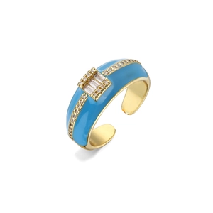 Detail of sky blue enamel gold-plated ring with central baguette and round zircon accents