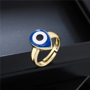 Gold plated open evil eye ring with blue teardrop enamel inlay on black display stand