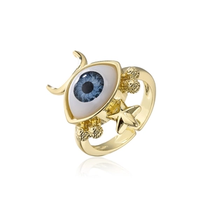 Macro detail of gold-plated evil eye ring with star and crescent moon accents