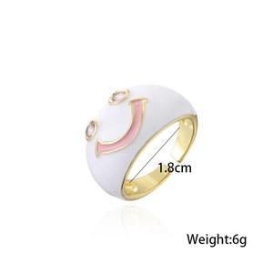 Detail eines goldenen verstellbaren Rings mit weißem Smiley-Gesicht und rosa Kristallen