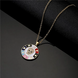 Collier pendentif crâne plaqué or avec roue tournante en émail coloré sur fond noir
