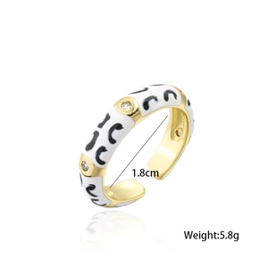 Detail view of gold ring with white enamel leopard print and clear cubic zirconia