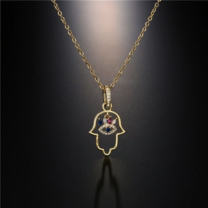 Gros plan détaillé de la main de Hamsa dorée avec zircon œil grec sur fond sombre