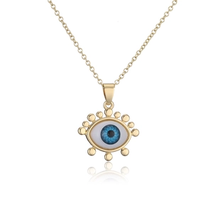 Macro view of gold-plated evil eye pendant with blue iris detail and sunburst beads