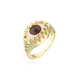 Macro shot of the 18K gold claw setting with a detailed brown resin evil eye on the open ring