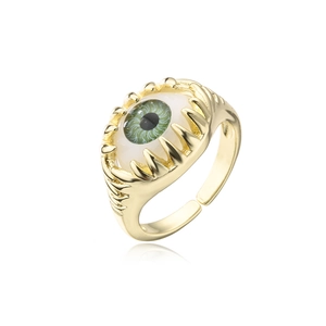 Detail of a punk 18K gold plated claw ring with a green evil eye and adjustable open band