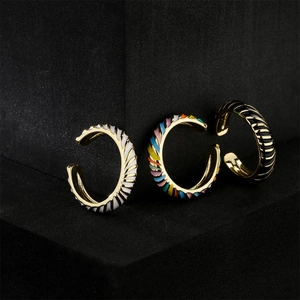 Set di tre anelli aperti placcati oro con motivi a spirale in smalto bianco, colorato e nero