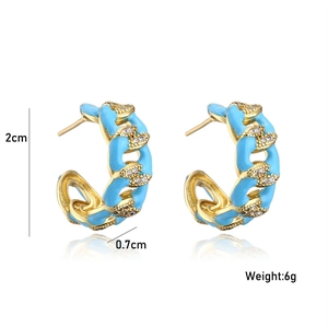 Detail of gold Cuban link hoop earrings with blue enamel and pavé zircon stones