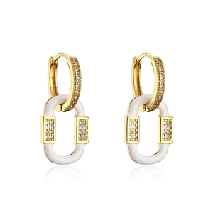 Macro detail of gold plated hoop earrings with white enamel and sparkling zircon stones