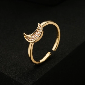Elegant gold crescent moon open ring with white cubic zirconia on a black background