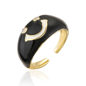 Détail d'une bague ouverte dorée avec smiley en émail noir et yeux en zircons étincelants